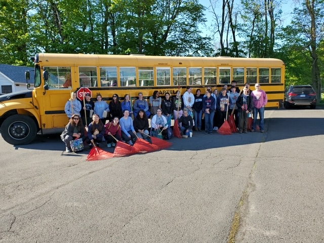 Student volunteers in front of a school bus